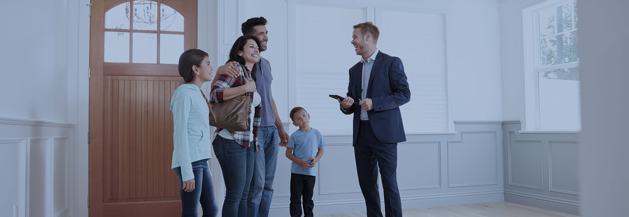 A family smiles as they engage with a real estate agent